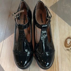 Women’s size 9 black patent leather shoes.